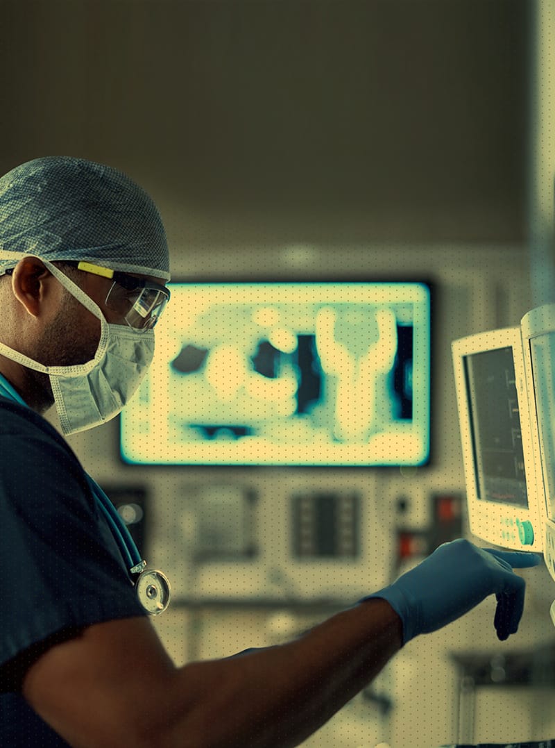 Medical doctor in operating room intently focuses on a computer screen