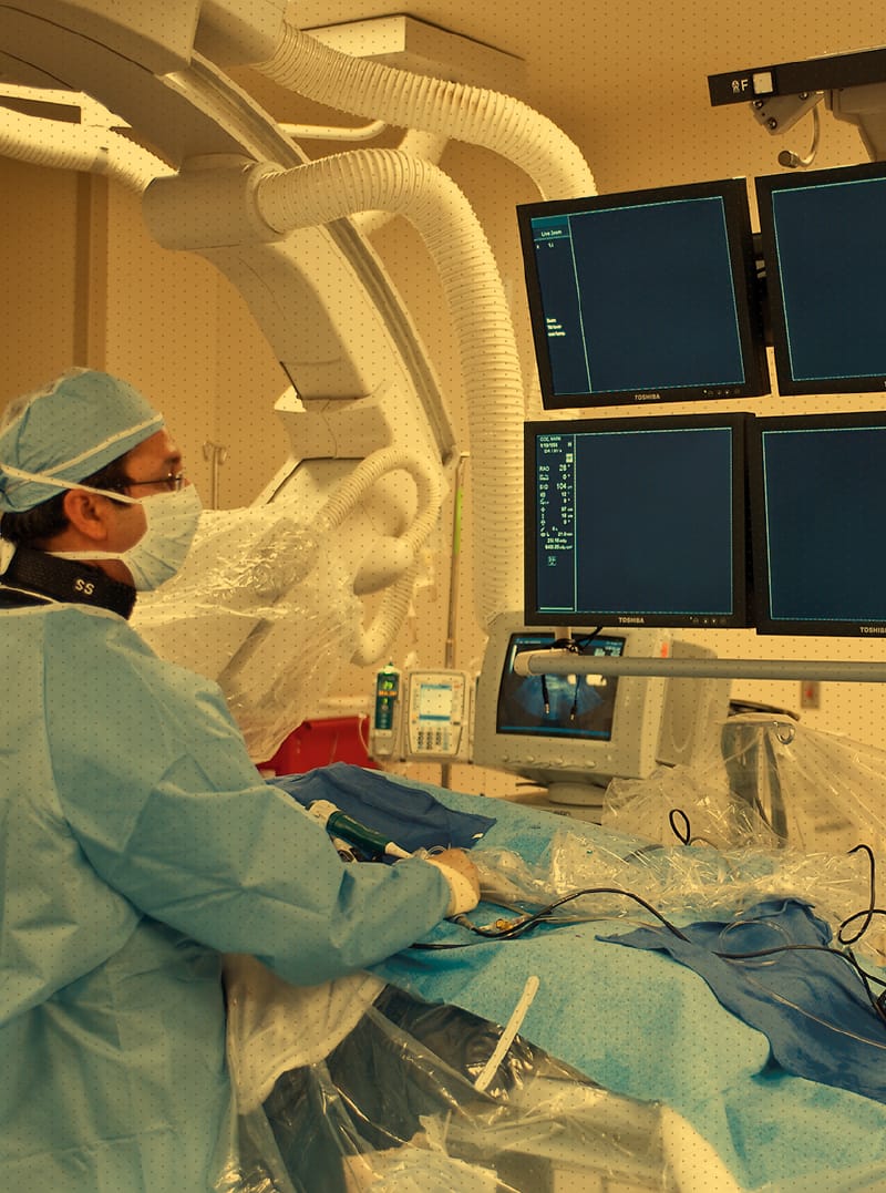 Surgeon in scrubs looking at screens during procedure