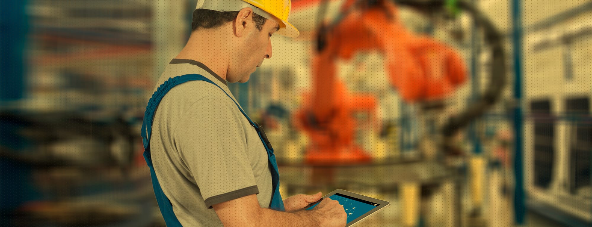 Mann mit gelbem Schutzhelm arbeitet in der Produktionsanlage